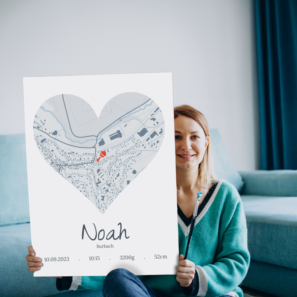 Großes rahmenloses Geburtsposter mit Herz-Stadtkarte vor blauem Sofa als individuelles Babygeschenk