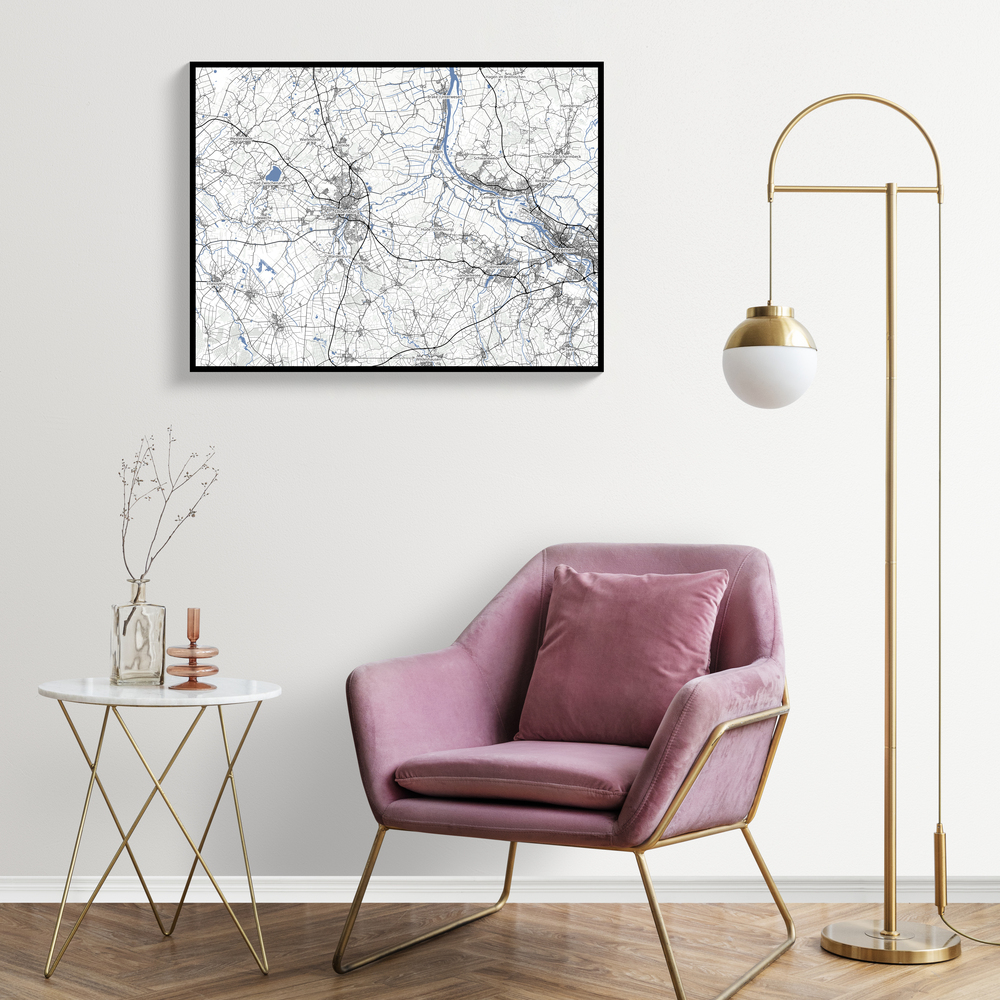 Individuelle Landkarte mit blauen Flüssen im schwarzen Rahmen über einem rosa Sessel neben einer goldenen Stehlampe