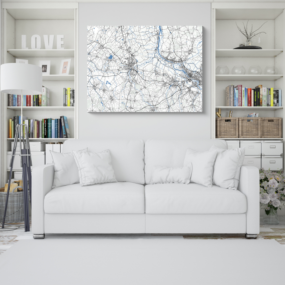 Randlose Landkarte mit grauen Straßen und blauen Flüssen über einem weißen Sofa zwischen Bücherregalen