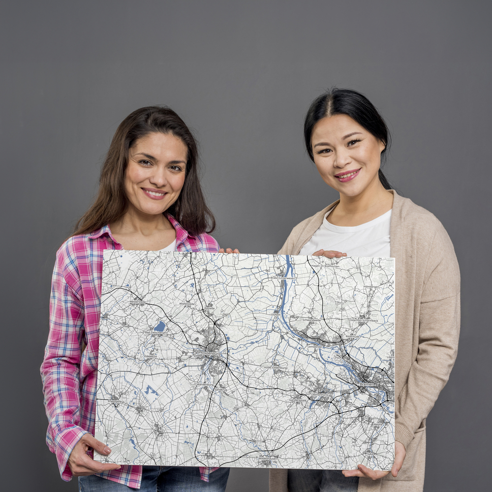 Großformatige Landkarte ohne Rahmen vor grauem Hintergrund, mit blauen Flüssen als Geschenk für Reisefans